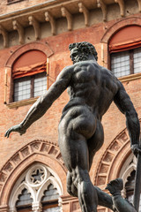 Fototapeta na wymiar Bronze statue of Neptune (1566), Roman God, fountain in Piazza del Nettuno, and Palazzo d'Accursio, Town hall in Bologna (XIII century). Emilia-Romagna, Italy, Europe. Artist Giambologna (1529-1608)