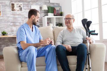 Fototapeta premium Elderly age man smiling while talking with male doctor
