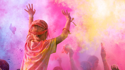 Holi Fest begeisterte Menschen jubeln auf einem Holifestival, tanzen und werfen mit buntem Holipulver