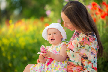 Happy woman and child on the poppy meadow.