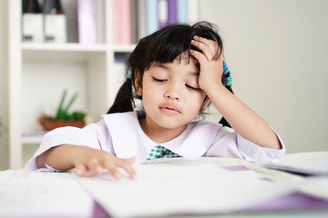 Little child girl concentrate and focusing to the homework for elementary school. thinking seriously for Educational solution concept.