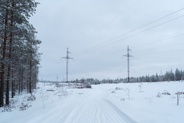 Winter landscape power lines in a snowy field in the forest