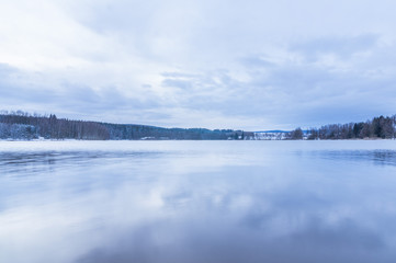 Sky and clounds reflecting in the lake in winter