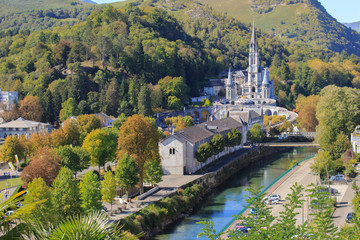 Lourdes landmark in the morning filtered. Cathedral of Our Lady of Lourdes with river and mountains. Famous pilgrimage centre. Rosary and sanctuary in Lourdes, France. Religious architecture. 