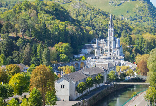 Lourdes landmark in the morning filtered. Cathedral of Our Lady of Lourdes with river and mountains. Famous pilgrimage centre. Rosary and sanctuary in Lourdes, France. Religious architecture. 