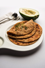 Raw Papaya Paratha or Papita ke Parathe made using Made using papaya, wheat flour, cumin seeds, ginger. Popular Indian food recipe served hot with curd. selective focus