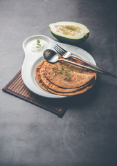 Raw Papaya Paratha or Papita ke Parathe made using Made using papaya, wheat flour, cumin seeds, ginger. Popular Indian food recipe served hot with curd. selective focus