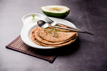 Raw Papaya Paratha or Papita ke Parathe made using Made using papaya, wheat flour, cumin seeds, ginger. Popular Indian food recipe served hot with curd. selective focus