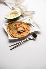 Raw Papaya Paratha or Papita ke Parathe made using Made using papaya, wheat flour, cumin seeds, ginger. Popular Indian food recipe served hot with curd. selective focus