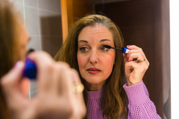 40-year-old woman putting on makeup and taking care of her skin