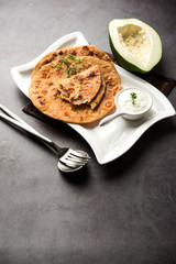 Raw Papaya Paratha or Papita ke Parathe made using Made using papaya, wheat flour, cumin seeds, ginger. Popular Indian food recipe served hot with curd. selective focus