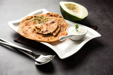 Raw Papaya Paratha or Papita ke Parathe made using Made using papaya, wheat flour, cumin seeds, ginger. Popular Indian food recipe served hot with curd. selective focus