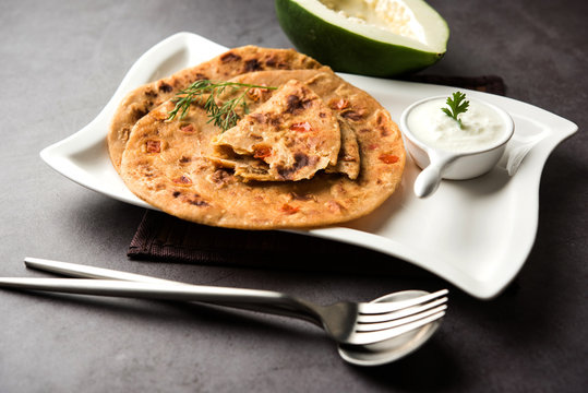 Raw Papaya Paratha or Papita ke Parathe made using Made using papaya, wheat flour, cumin seeds, ginger. Popular Indian food recipe served hot with curd. selective focus