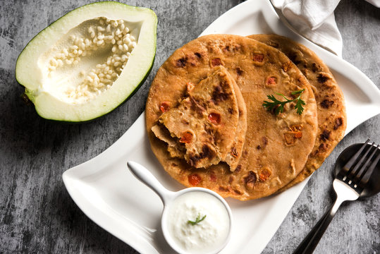 Raw Papaya Paratha or Papita ke Parathe made using Made using papaya, wheat flour, cumin seeds, ginger. Popular Indian food recipe served hot with curd. selective focus
