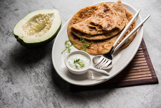 Raw Papaya Paratha or Papita ke Parathe made using Made using papaya, wheat flour, cumin seeds, ginger. Popular Indian food recipe served hot with curd. selective focus