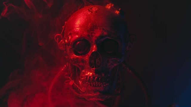 Robotic skull in red light with smoke
