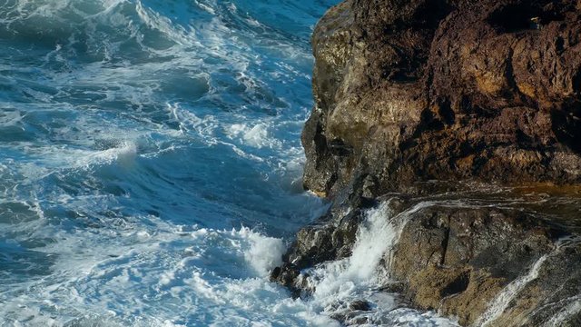 Storm in the Atlantic Ocean Waves Break the rocks of the shore Water turns into Foam Droplets and Splashes Clear Blue water of the Sea. Gale Tide is playing with the Sun shot slow motion URSA 4.6K