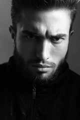 Close-up black and white portrait of a young handsome Caucasian male in studio. A man shows different human emotions.
