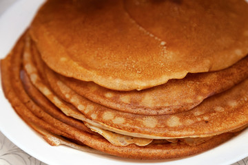 A stack of delicious hot and fresh thin pancakes baked in a pan of milk, flour and eggs for breakfast at home. Russian national holiday Shrovetide.
