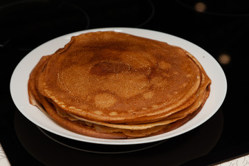 A stack of delicious hot and fresh thin pancakes baked in a pan of milk, flour and eggs for breakfast at home. Russian national holiday Shrovetide.