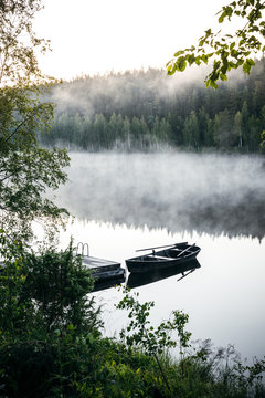 Old rowing boat by the lake a serene & foggy summer morning