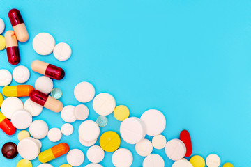 Different pills on blue background, top view and space for text