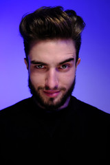 Obraz premium Beautiful caucasian young man portrait isolated on multicolored neon light backgroud. Young, smiling, surprised, screaming. Human emotions, facial expression concept. Trendy colors.Advertising concept