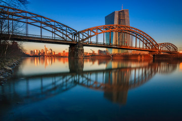 Obraz na płótnie Canvas bridge over river, The frankfurt skyline in the morning, framed by a bridge.