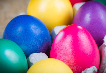 Obraz na płótnie Canvas Close-up of multicolored traditional easter eggs painted in blue, pink, purple, yellow colors. Macrophotography. Vibrant easter festive background.