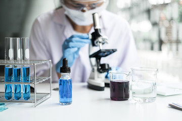 Fototapeta premium Biochemistry laboratory research, Chemist is analyzing sample in laboratory with Microscope equipment and science experiments glassware containing chemical liquid