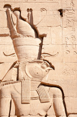 Sunny portrait in hieroglyph relief of ancient Egyptian falcon god Horus in Edfu, Egypt