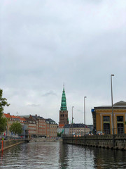 Fototapeta na wymiar Tourist boat on Gammel Strand canal. Nikolaj Kirke Church and Thorvaldsens museum on the background at Copenhagen, Denmark