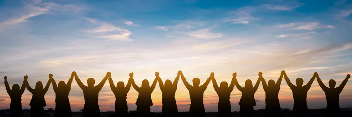 Fotobehang Silhouette of group happy business team making high hands over head in beautiful sunset sky evening time for business success and teamwork concept in company © Guitafotostudio