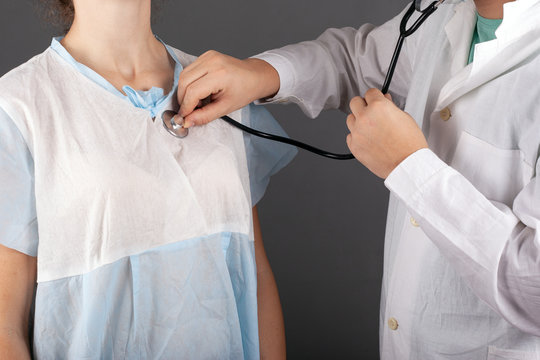 the doctor listens to the patient's heartbeat with a statoscope on a dark background. medical ambulance examination treatment inspection