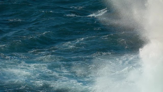 Extreme Wave crashing coast Awesome power of waves breaking over dangerous rocks spray wind waves Sea Huge swell hitting shoreline.  Tide turns into pearl drops and splashes Powerful Ocean shot 4.6K