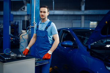 Worker in uniform at the toolbox, car service