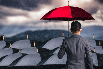 The double exposure image of the Businessmen are spreading umbrella during raining. The concept of...