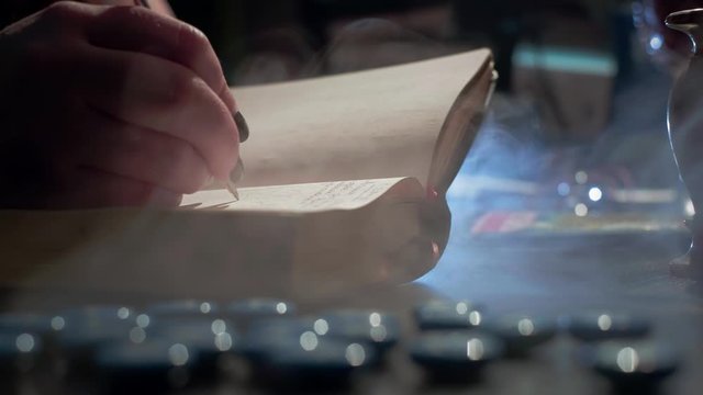 The witch is reading a magic book. Makes notes of a ritual ceremony. Conducts a spiritualistic session, communicates with the spirits and souls of the dead. Paranormal activity