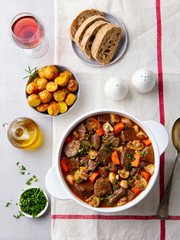 Beef bourguignon stew with vegetables. Grey background. Top view. - 328039725
