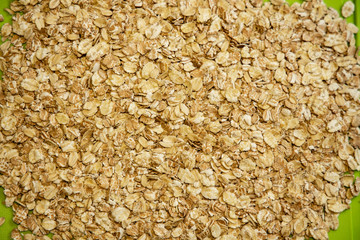 raw oatmeal flakes healthy food for breakfast life style concept background picture with green board on bottom