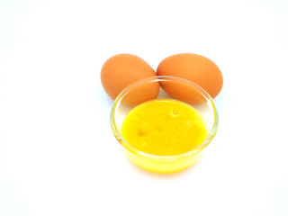Mix the eggs in a glass bowl, to prepare as an ingredient for cooking or baking in the kitchen isolated on white background.