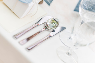 Long dinner tables, served with porcelain and glasses and rich decorated with flowers stand on the roof of a house. Bokeh lights on baclground