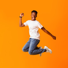 Fototapeta na wymiar Excited screaming african man jumping while celebrating