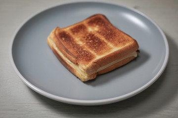 Toasted ham and cheese sandwich in a dish.