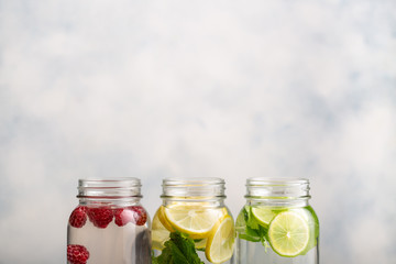Detox water in jars with raspberries, lemon, lime and mint.