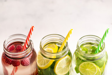Detox water in jars with raspberries, lemon, lime and mint.