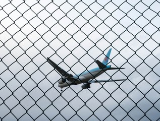 Landendes Flugzeug hinter Zaun 