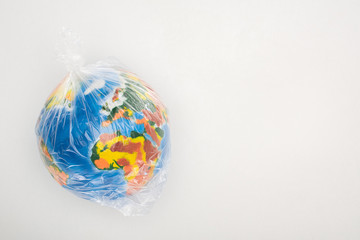 Top view of globe in plastic bag on white background, global warming concept
