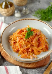 Braised cabbage with ham, onions and carrots. Traditional Russian food