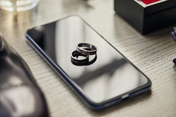 Wedding rings lie on the phone. Different accessories of businessman for creating style of  people...
